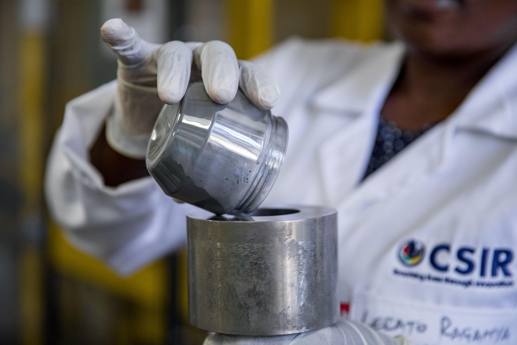 Hand holding a container with yellowish liquid