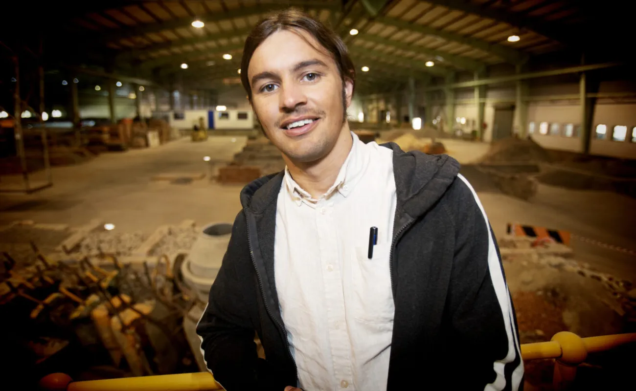 Hand holding a container with yellowish liquid