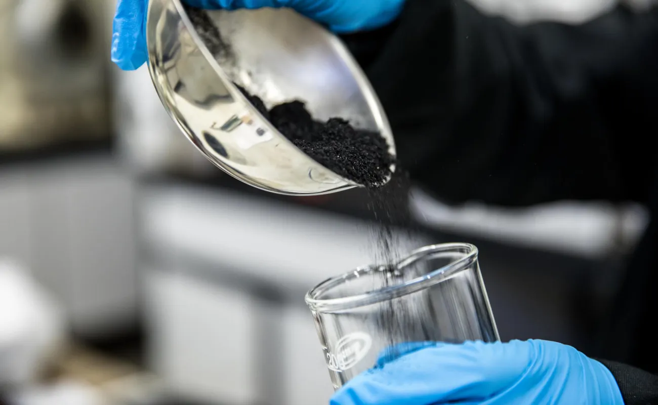 Hand holding a container with yellowish liquid